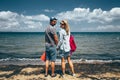 Couple Travelers Man And Woman Standing On Seashore And Looks At The Camera Adventure Travel Journey Concept