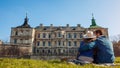 Couple of travelers relaxes enjoying view of Pidhirtsi castle. Ancient architecture landmark. Tourism in Westerm Ukraine Royalty Free Stock Photo