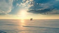 The couple of travelers walking through the snow field on sunset background. Royalty Free Stock Photo