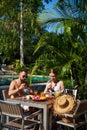 Couple of travellers eating food in hotel near swimming pool