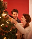 Couple, tree and christmas with smile, decoration and celebration for holiday spirit. Man, woman and love with happy