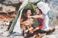 Couple of trekker sitting in the tent with their pet - Happy man and woman having fun in vacation camping around rock mountain Royalty Free Stock Photo