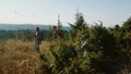 Couple trekking in mountains. Travelers with ski poles hiking in grassy field Royalty Free Stock Photo