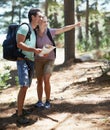 Couple, trekking in nature and map for direction, documents guide or location information of forest travel or journey