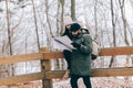 Couple trekking in winter in the forest looking at map. Royalty Free Stock Photo