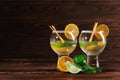 Two cocktails with rum and fruits. Appetizer fruits and spicy mint for a cold drink. Cocktails on the wooden background. Royalty Free Stock Photo