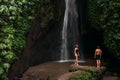 Couple at a tropical waterfall. The couple travels to the island of Bali in Indonesia. A woman and a man at a beautiful waterfall Royalty Free Stock Photo