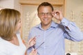 Couple trying on eyeglasses at optometrists