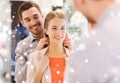 Couple trying golden pendant on at jewelry store