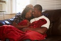 Couple Trying To Keep Warm Under Blanket At Home