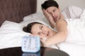 Couple turning off or snoozing alarm clock, waking up problem Royalty Free Stock Photo