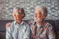 Couple of two beautiful and cute seniors at home sitting on the sofa looking at the window wearing glasses together Royalty Free Stock Photo