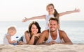 Couple with two children lying on beach Royalty Free Stock Photo