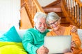Couple of two happy mature and old people or seniors at home sitting on the sofa enjoying and having fun together looking and Royalty Free Stock Photo