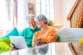 Couple of two happy mature and old people or seniors at home sitting on the sofa enjoying and having fun together looking and Royalty Free Stock Photo