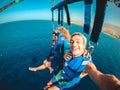 Couple of two happy people enjoying summer and vacations doing extreme activity on the sea with a boat - beautiful people taking a Royalty Free Stock Photo