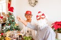 Couple of two happy seniors eating and having fun the christmas day at lunch - christmas tree at the background - smiling and Royalty Free Stock Photo