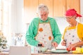 Couple of two happy seniors having fun and cooking together in the kitchen of their home - preparing some healthy food with Royalty Free Stock Photo