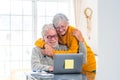 Couple of two happy seniors working and using laptop together at home smiling and having fun together - lockdown lifestyle Royalty Free Stock Photo