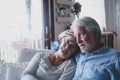 Couple of two sad and depressed old people sitting on the sofa at home looking outside the window. Lockdown and quarantine Royalty Free Stock Photo