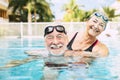 Z dve seniori objala v voda z plávanie bazén aktívne muž a žena robiť cvičenie spoločne na bazén objala 