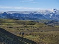 Couple of two young hikers at Laugavegur hiking trail with eyjafjallajokull volcano and glacier tongue, blue river