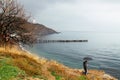 Couple with umbrella walking in rain. Couple travel in rainy weather near sea. Crimea