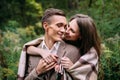 Couple under the plaid in an autumn romantic forest. Autumn wedding outdoors. Royalty Free Stock Photo