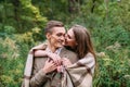 Couple under the plaid in an autumn romantic forest. Autumn wedding outdoors.