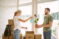 Couple unpack boxes in new home. Woman giving flower to her husband Royalty Free Stock Photo