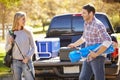 Couple Unpacking Pick Up Truck On Camping Holiday