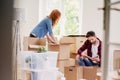 Couple unpacking stuff from carton boxes while moving-into new home Royalty Free Stock Photo
