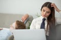 Couple uses laptop sitting on sofa. Beautiful woman working at home while her husband resting. Tired stressed woman