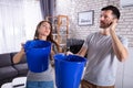 Couple Using Bucket For Collecting Water Leakage From Ceiling Royalty Free Stock Photo