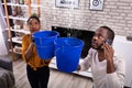 Couple Using Bucket For Collecting Water Leakage From Ceiling Royalty Free Stock Photo