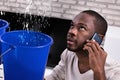 Couple Using Bucket For Collecting Water Leakage From Ceiling Royalty Free Stock Photo