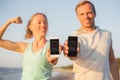 Couple using fitness app on their mobile phones Royalty Free Stock Photo