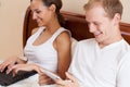 Couple using internet in bed