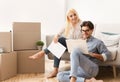 Couple using laptop reading certificate of property on couch