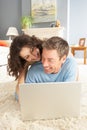 Couple Using Laptop Relaxing Laying On Rug At Home Royalty Free Stock Photo
