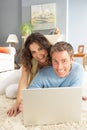 Couple Using Laptop Relaxing Laying On Rug At Home Royalty Free Stock Photo