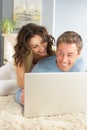 Couple Using Laptop Relaxing Laying On Rug At Home Royalty Free Stock Photo