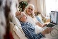 Couple using laptop while sitting on the bed Royalty Free Stock Photo