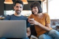 Couple using laptop while sitting on couch at home. Royalty Free Stock Photo