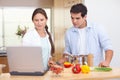 Couple using a laptop to cook Royalty Free Stock Photo