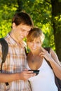 Couple using mobile phone outdoors Royalty Free Stock Photo