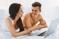 Couple using notebook on bed Royalty Free Stock Photo