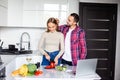 Young couple using a notebook to cook in their kitchen Royalty Free Stock Photo