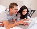 Couple using notebook together in the bedroom Royalty Free Stock Photo