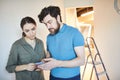 Couple Using Smartphone in New House